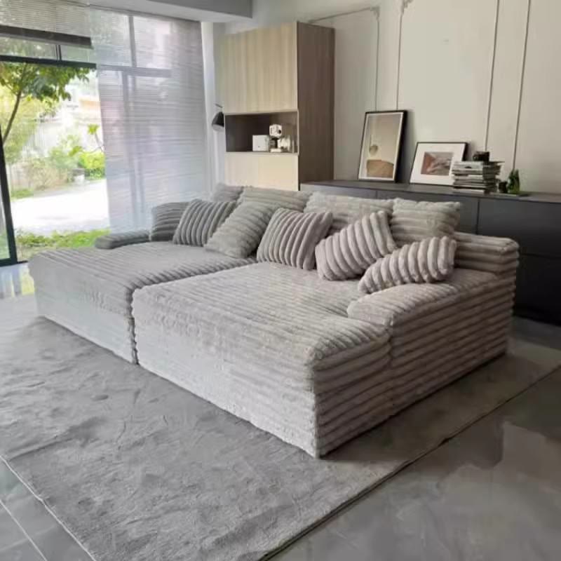Jerry's grey sectional sofa bed with striped pillows in a modern living room